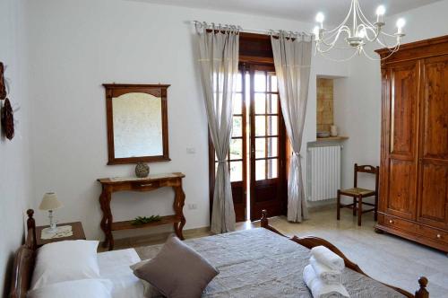 トリカーゼにあるB&B Profumo di Alloroのベッドルーム1室(ベッド1台、鏡、窓付)