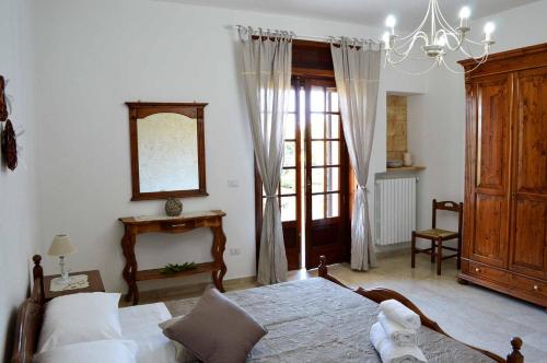 a bedroom with a bed and a mirror and a window at B&B Profumo di Alloro in Tricase