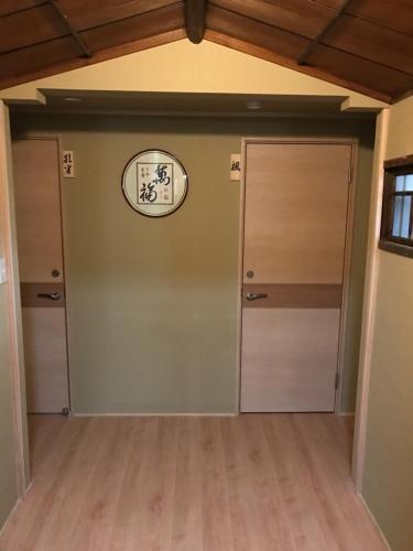 a room with two doors and a clock on the wall at Ryokan Seifuso in Ōmuta