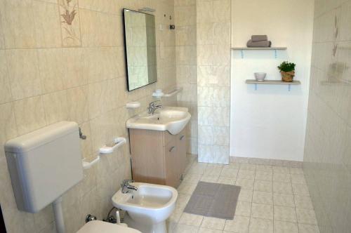 ein Badezimmer mit einem Waschbecken, einem WC und einem Spiegel in der Unterkunft B&B Profumo di Alloro in Tricase