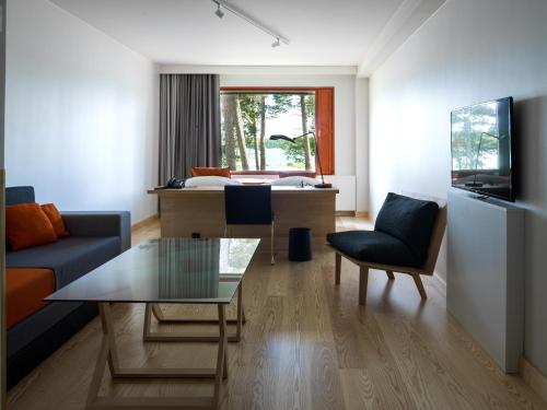 a living room with a couch and a table at Hotel Hanasaari in Espoo