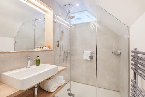 a bathroom with a sink and a shower at Hotel Gasthof zum Ochsen in Arlesheim