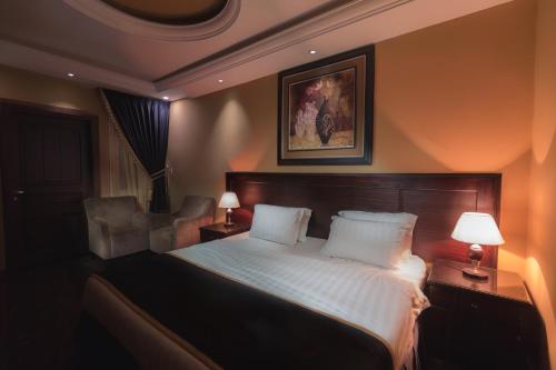 a bedroom with a bed with two pillows and two lamps at منتجع مارينا جويل in Khamis Mushayt