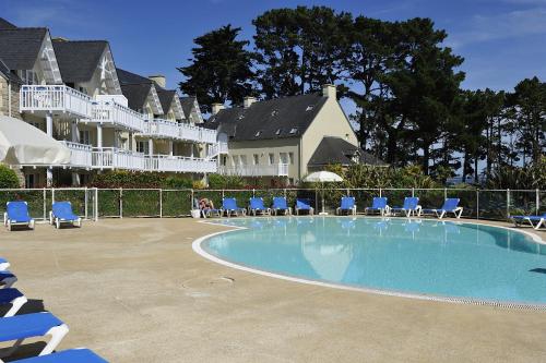 ein großer Pool mit Stühlen und ein Haus in der Unterkunft Residence Cap Azur - maeva Home in Fouesnant