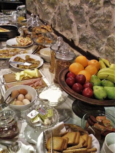 a table topped with lots of different types of food at Vergoula's Mansion in Kastoria
