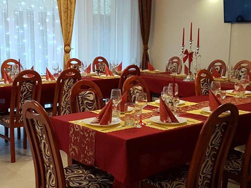 a dining room with tables and chairs with red table cloth at Penzión Dúhový Pstruh in Bystrá