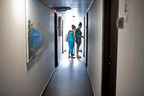 a couple of people standing in a hallway at Miami Beach Hotel Tel Aviv in Tel Aviv