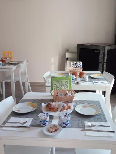 a white table with plates of donuts on it at Nelle Stanze Del Matese in Boiano