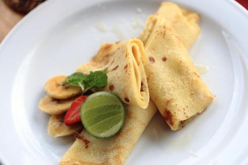 um prato branco com alguma comida em Sagitarius Inn em Ubud