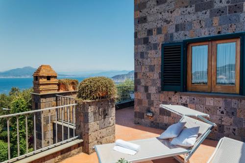 a patio with a table and chairs on a balcony at Villa Carolina Sorrento Private Heated Pool and Sea View in Sorrento