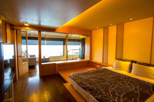 ein Schlafzimmer mit einem Bett und einem großen Fenster in der Unterkunft 5 KM Villa in Renai