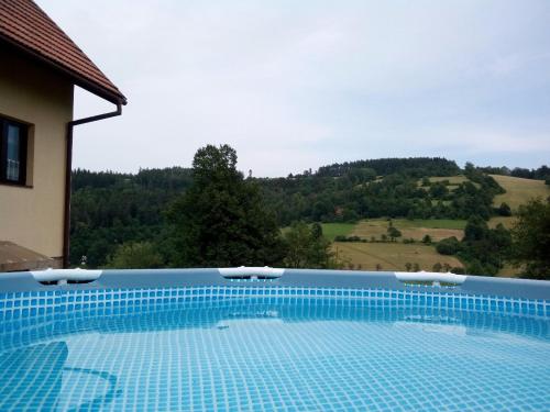 einen blauen Pool mit Bergblick in der Unterkunft Chata Malá Bystřice in Malá Bystřice