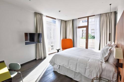 a hotel room with a bed and a chair and window at The Fourth - Tafelrond in Leuven