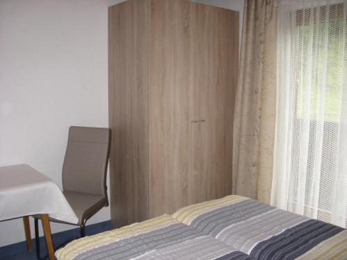 a bedroom with a bed and a chair next to a window at Ferienwohnung Wohlfarter in Jerzens
