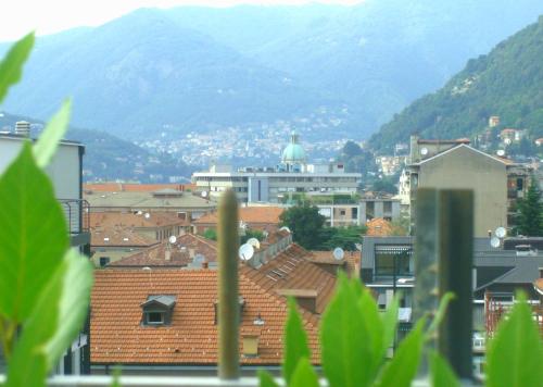 a view of a city with buildings and mountains at Hotel Como in Como