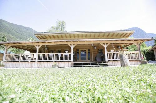 a large wooden house with a large porch at Adventure Camp in Oetz