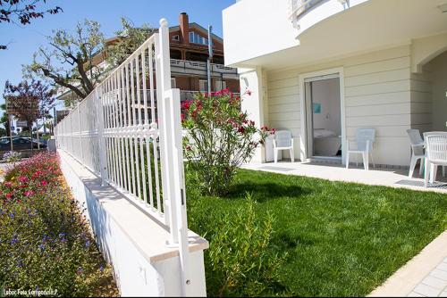 a white railing in the yard of a house at Residence Acquasuite in Martinsicuro