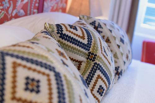 a group of pillows sitting on a bed at Durrell Liston Suites in Corfu Town