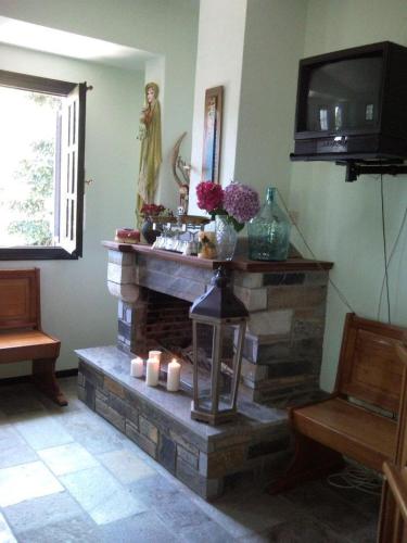 a living room with a fireplace with candles and a television at Dimosthenis Karastamatis Rooms in Xorychti