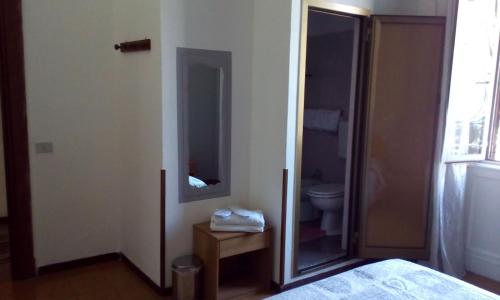 a bedroom with a bathroom with a toilet and a mirror at Hotel Tirreno in Milan