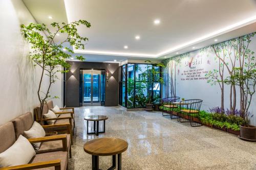 a lobby with tables and plants on the wall at Livotel Hotel Hua Mak Bangkok in Bangkok