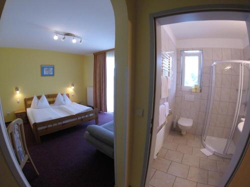 a hotel room with a bed and a shower at Gasthof Zum Lindenhof in Bad Radkersburg