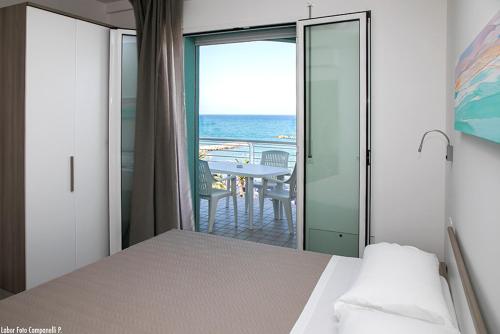 a bedroom with a bed and a view of the ocean at Residence Acquasuite in Martinsicuro
