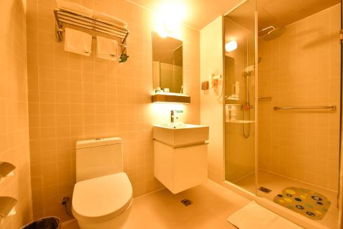 a bathroom with a toilet and a shower and a sink at Jinjiang Inn Haikou Binhai Avenue Qilou Old Street in Haikou