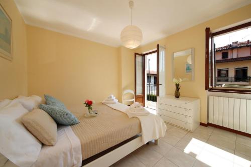 a bedroom with a bed with towels and a window at Petalo Bianco 100m from lake - Happy Rentals in Baveno
