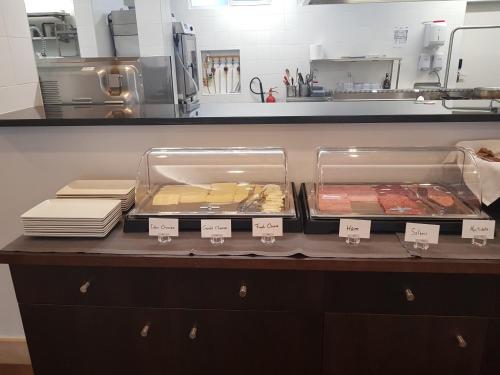 Un mostrador en una cocina con bandejas de comida. en Santa Cruz Village Hotel, en Santa Cruz