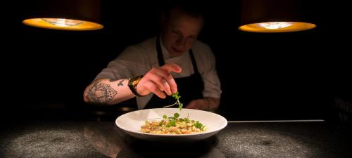 a chef is preparing a bowl of food at Hotel Verso in Jyväskylä