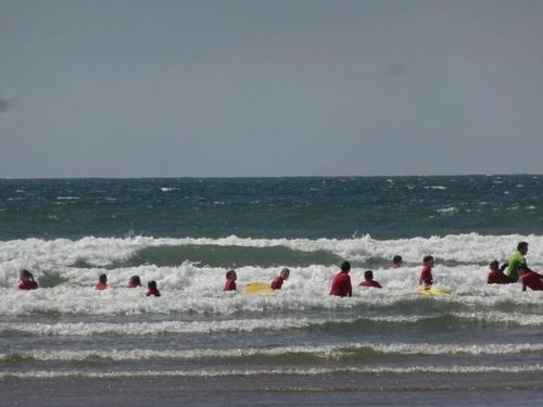 a group of people in the ocean with surfboards at Home from Home B&B in Hartland