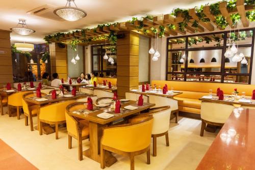 a restaurant with wooden tables and yellow chairs at Sangai Continental (The Boutique Hotel) in Imphal