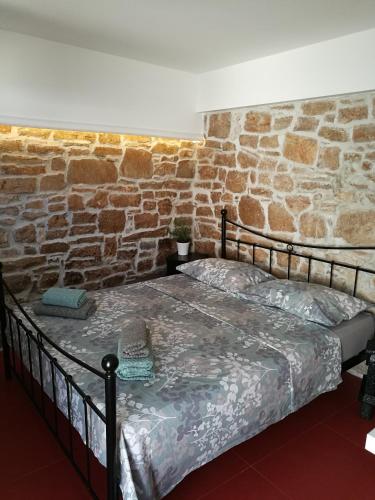 a bed in a room with a brick wall at Littel studio Franceska in Jezera