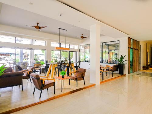 a living room with chairs and a dining room at The Rich Hotel in Nakhon Ratchasima