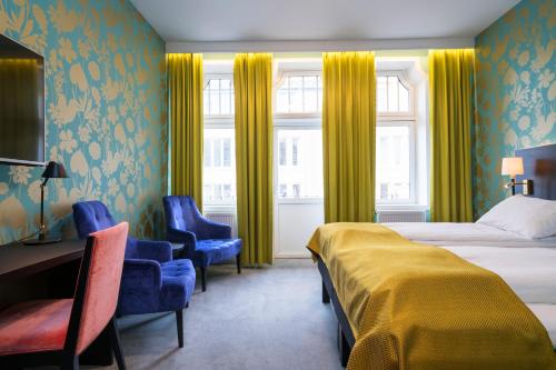 ein Hotelzimmer mit einem Bett, einem Schreibtisch und Stühlen in der Unterkunft Thon Hotel Nidaros in Trondheim