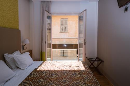 a bedroom with a bed and a window in a room at Victoria Hotel in Nafplio