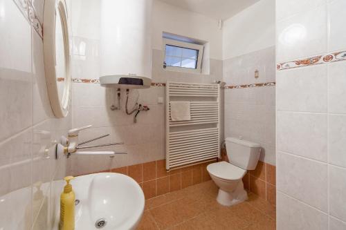 a white bathroom with a toilet and a sink at Penzion Šalamoun in Jevišovice
