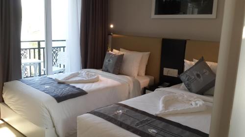 a hotel room with two beds and a balcony at Muine Sports Hotel in Mui Ne