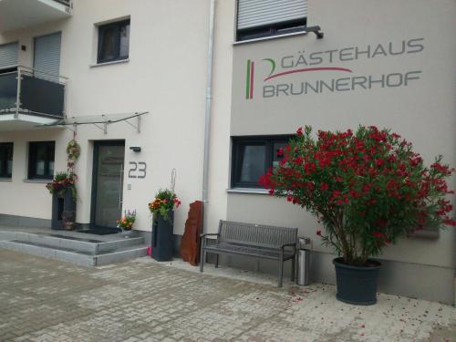 a building with a bench in front of a building at Gästehaus Brunnerhof - Eitting in Eitting