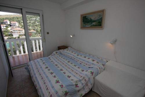 a bedroom with a bed and a balcony at Apartments Pavao in Ražanj