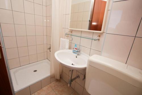 a bathroom with a sink and a toilet and a shower at Apartments Pavao in Ražanj