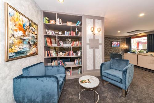 a living room with two blue chairs and a book shelf at Vicenza Hotel Istanbul Old City in Istanbul