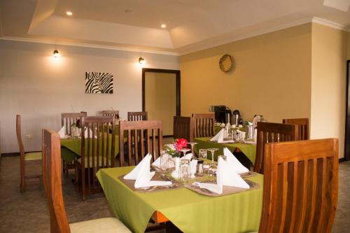 a dining room with tables and chairs with flowers on them at Airport Planet Lodge in Kingori