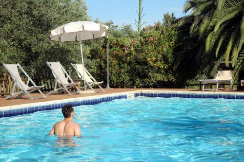 a man in the water in a swimming pool at Casale Vigna Carbona in Gavorrano