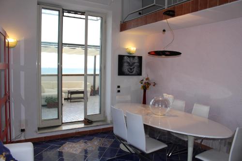 uma sala de jantar com uma mesa branca e cadeiras brancas em Attico Blu em Nápoles