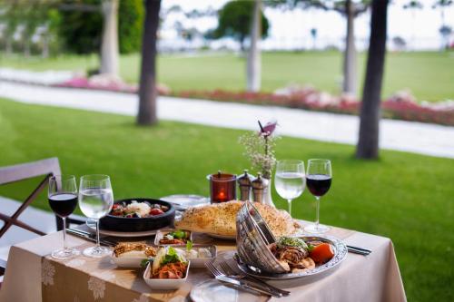 a table with glasses of wine and food on it at Lara Barut Collection-Ultra All Inclusive in Lara