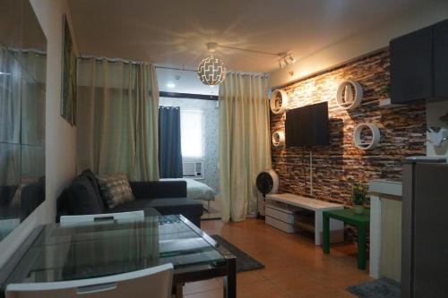 a living room with a couch and a brick wall at Apartelle D' Oasis in Davao City