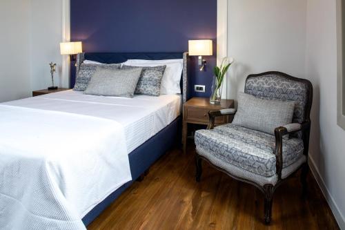 a bedroom with a bed and a chair at Gambello Luxury Rooms in Nafplio