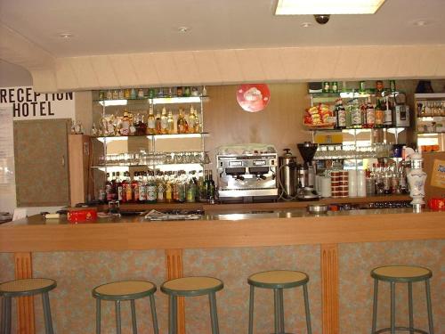 a bar with four bar stools in a restaurant at Hotel La Reserve in Vic-la-Gardiole